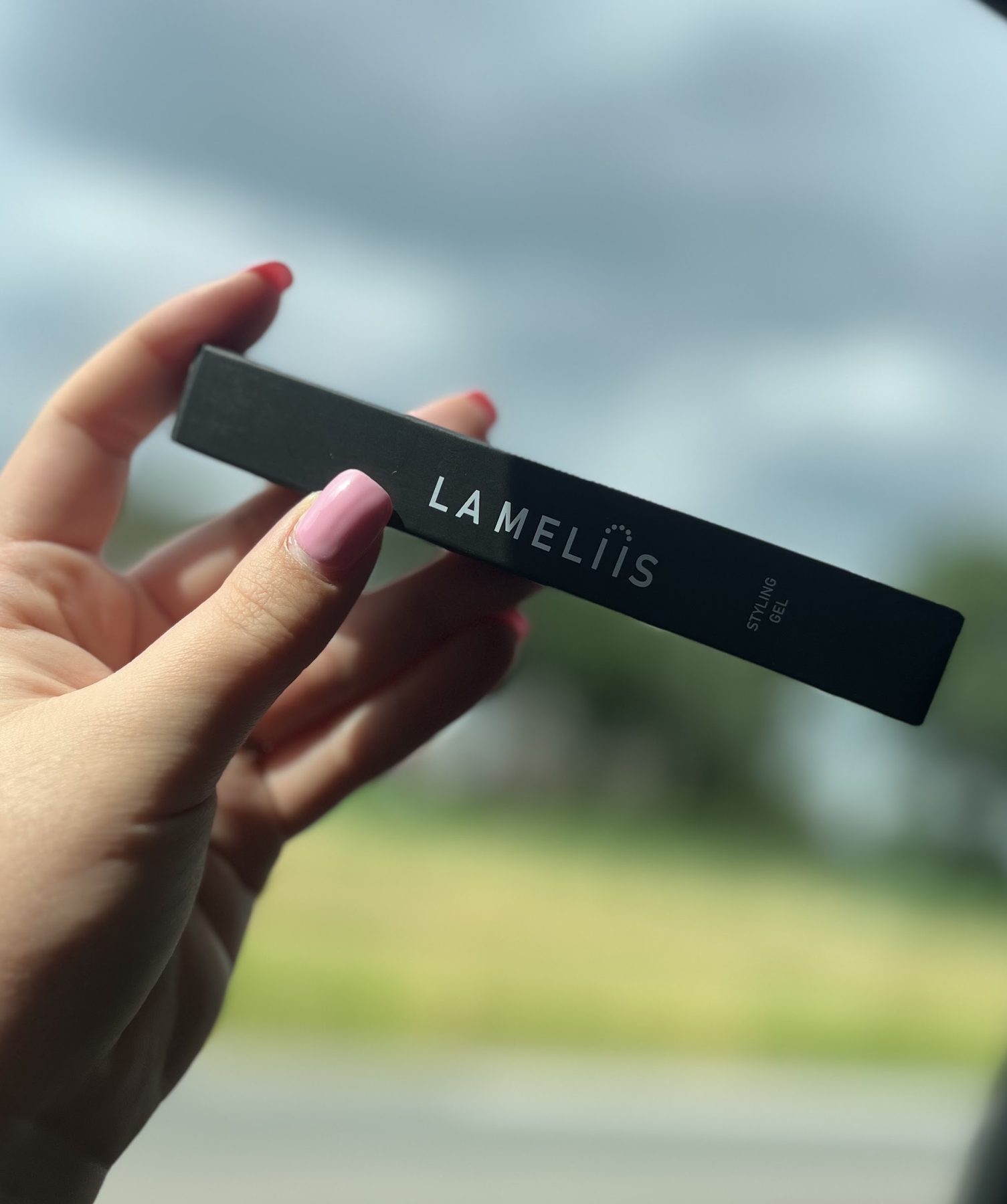 Een hand met een tube La Meliis styling gel, buiten